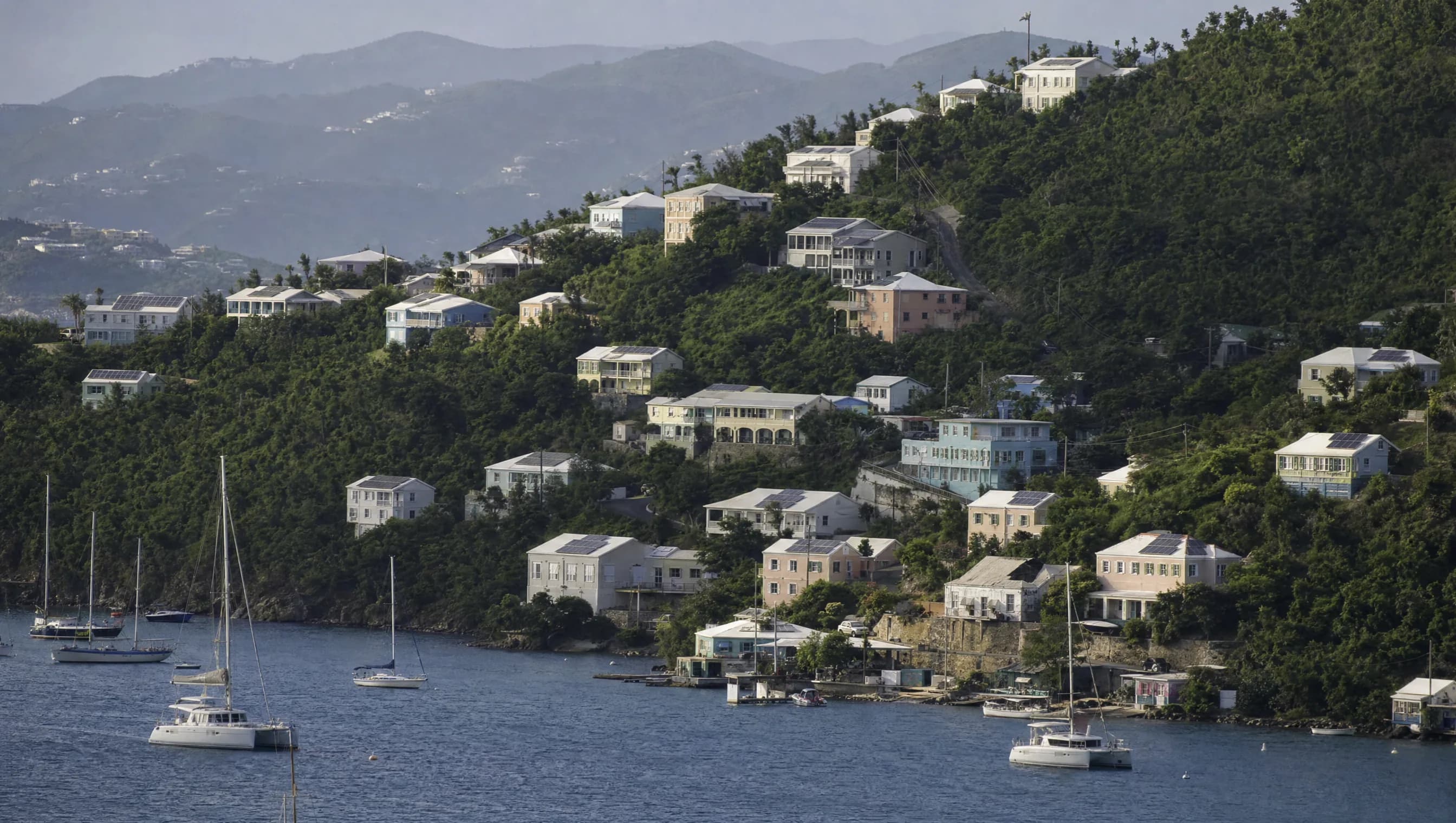 A Virgin Islands hillside of homes stepping down toward the harbour